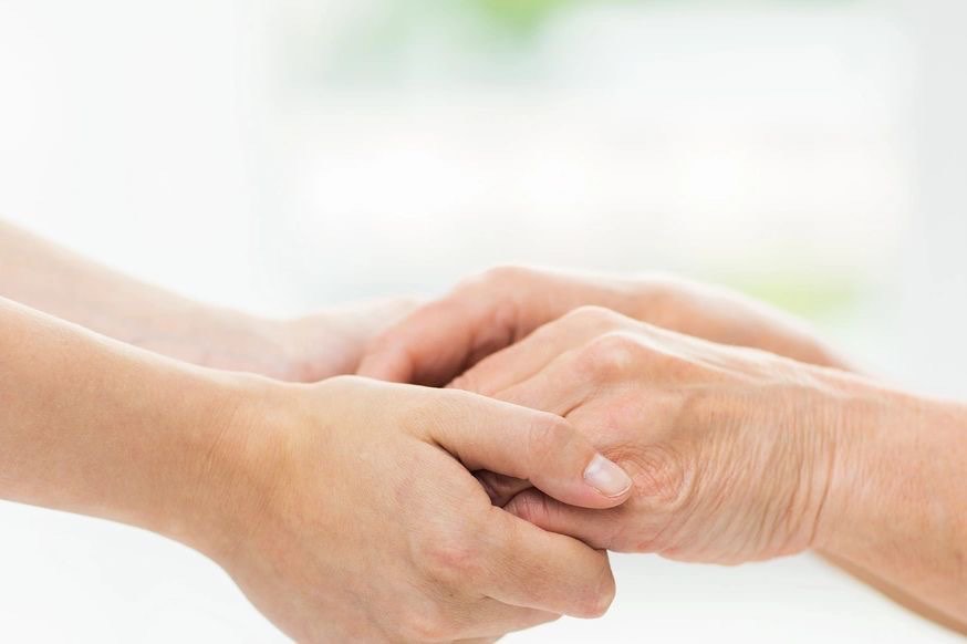 Two people holding hands, one older and one younger